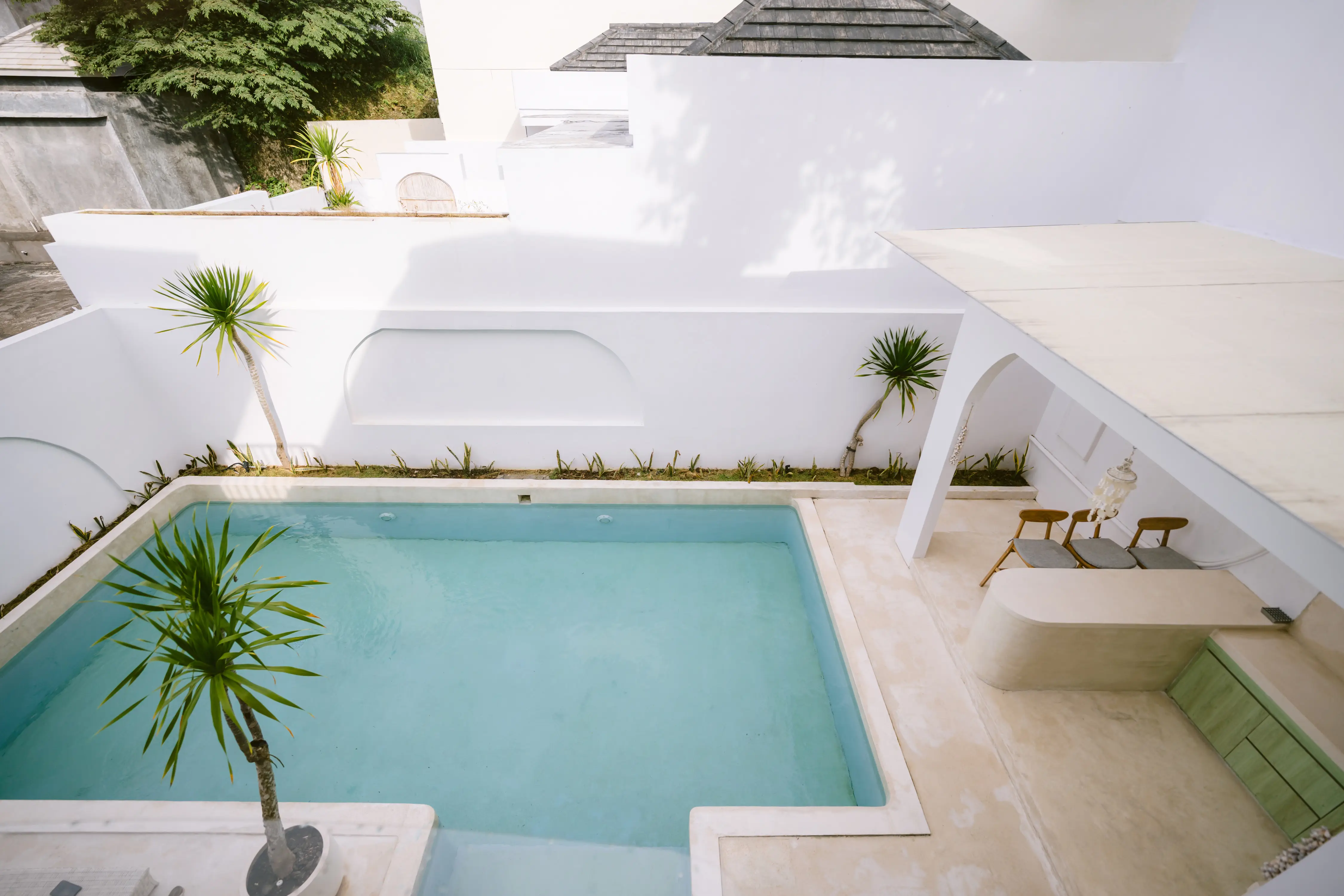 Minimal travertine bathroom with rain shower and pale stone basin