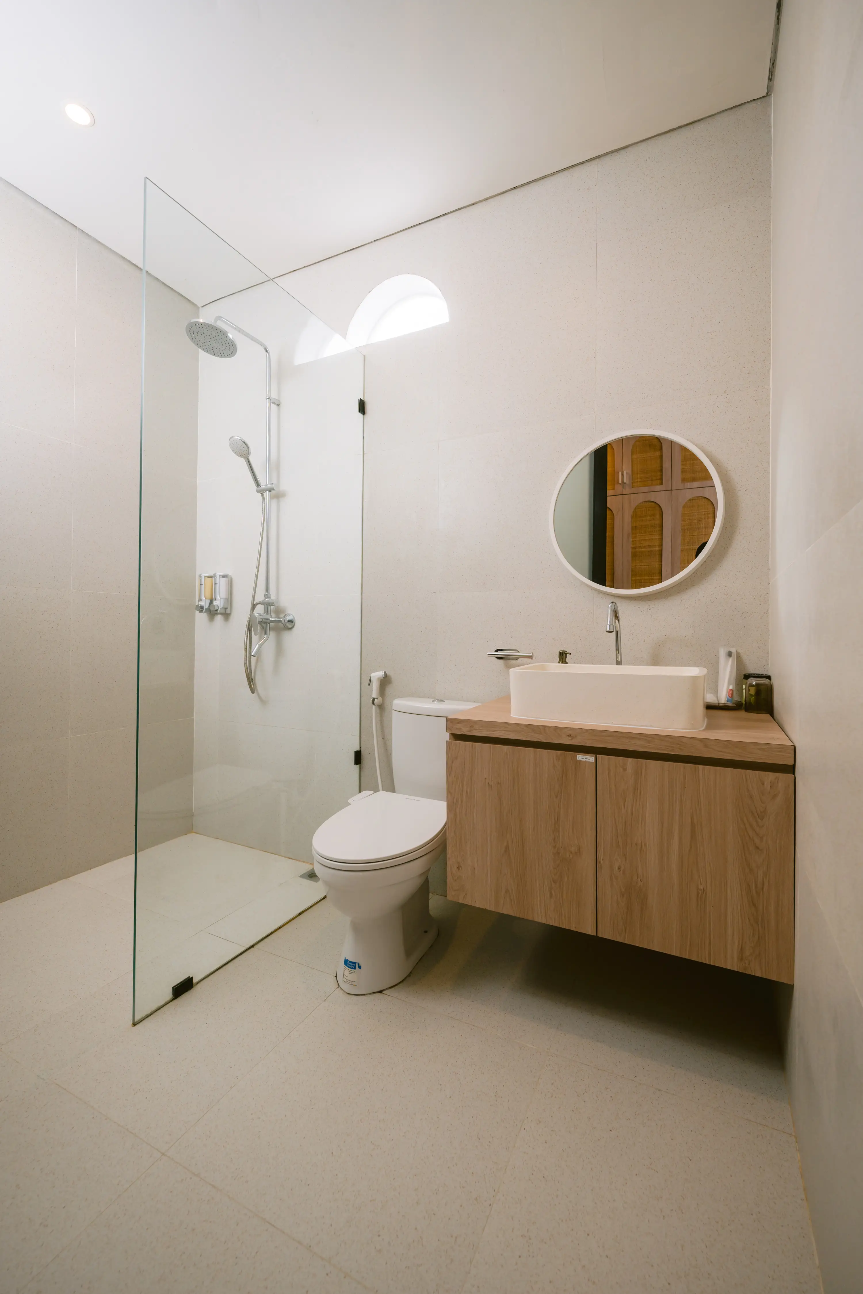 Minimal travertine bathroom with rain shower
