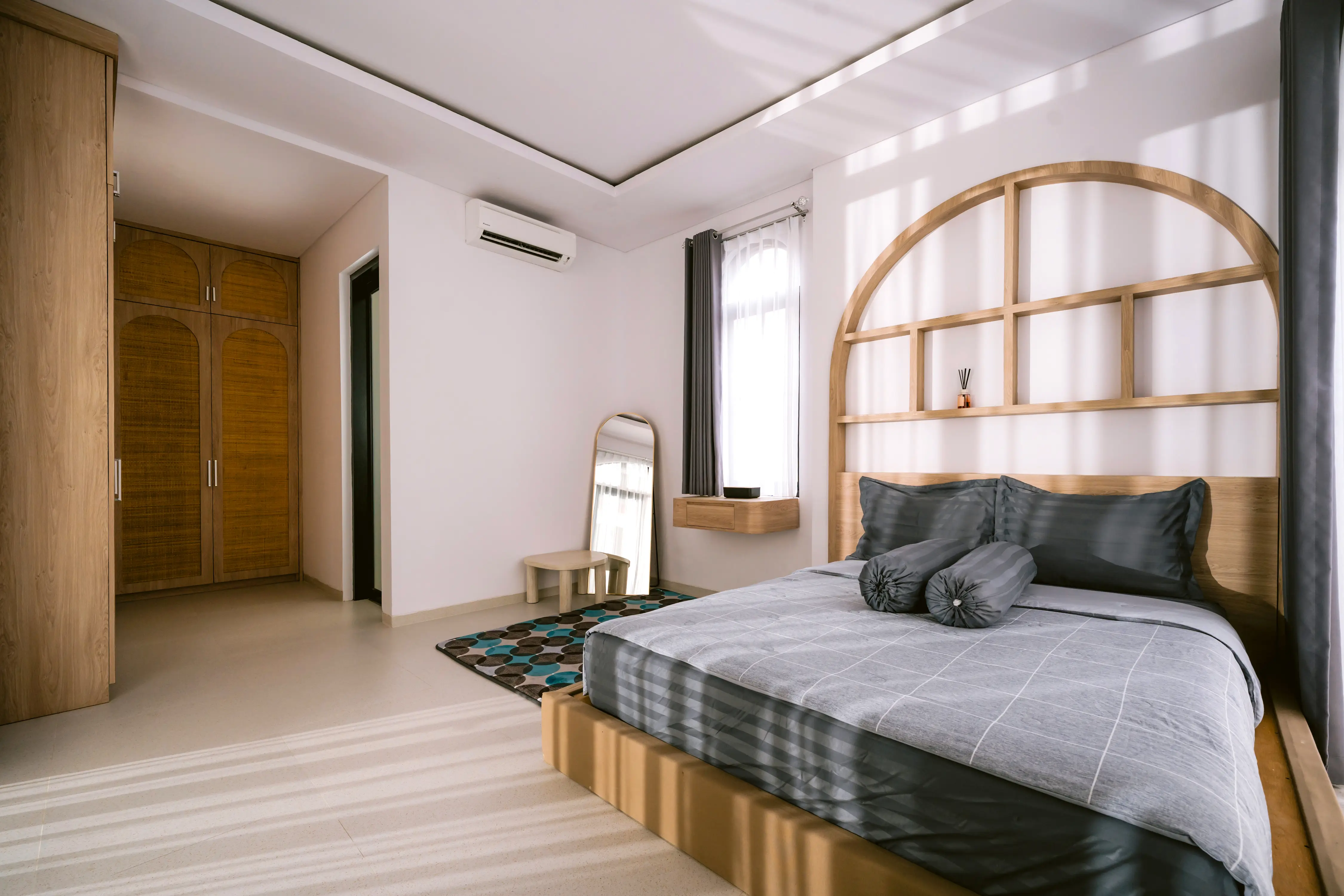 Bedroom with full-height arched dark wood headboard