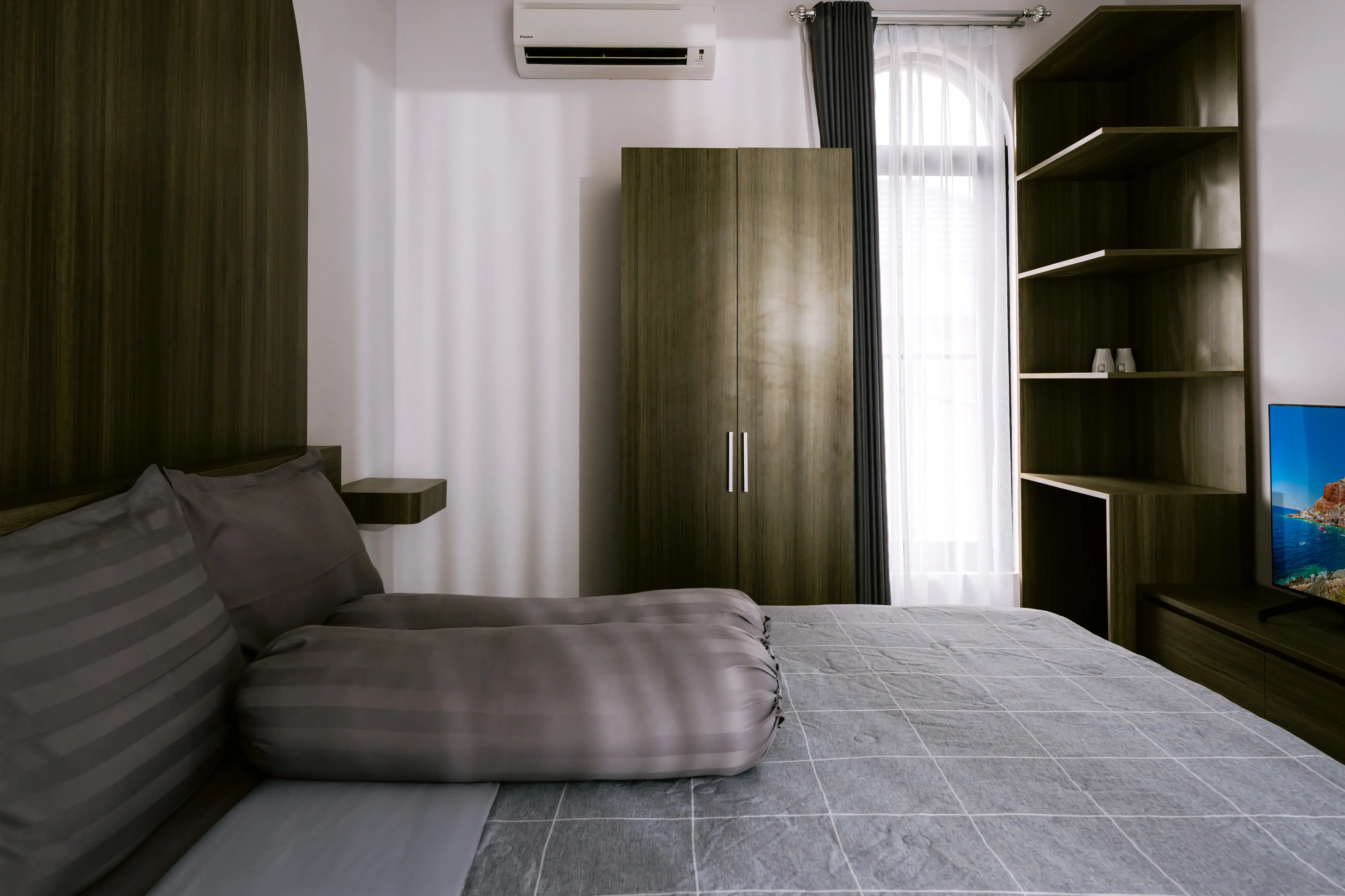 Bedroom with tall wood wardrobe and shelving