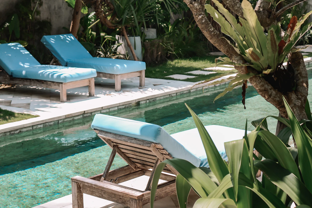 A tropical resort swimming pool with lounge chairs and palm trees — the kind of private-pool setup that makes Bali easy with kids