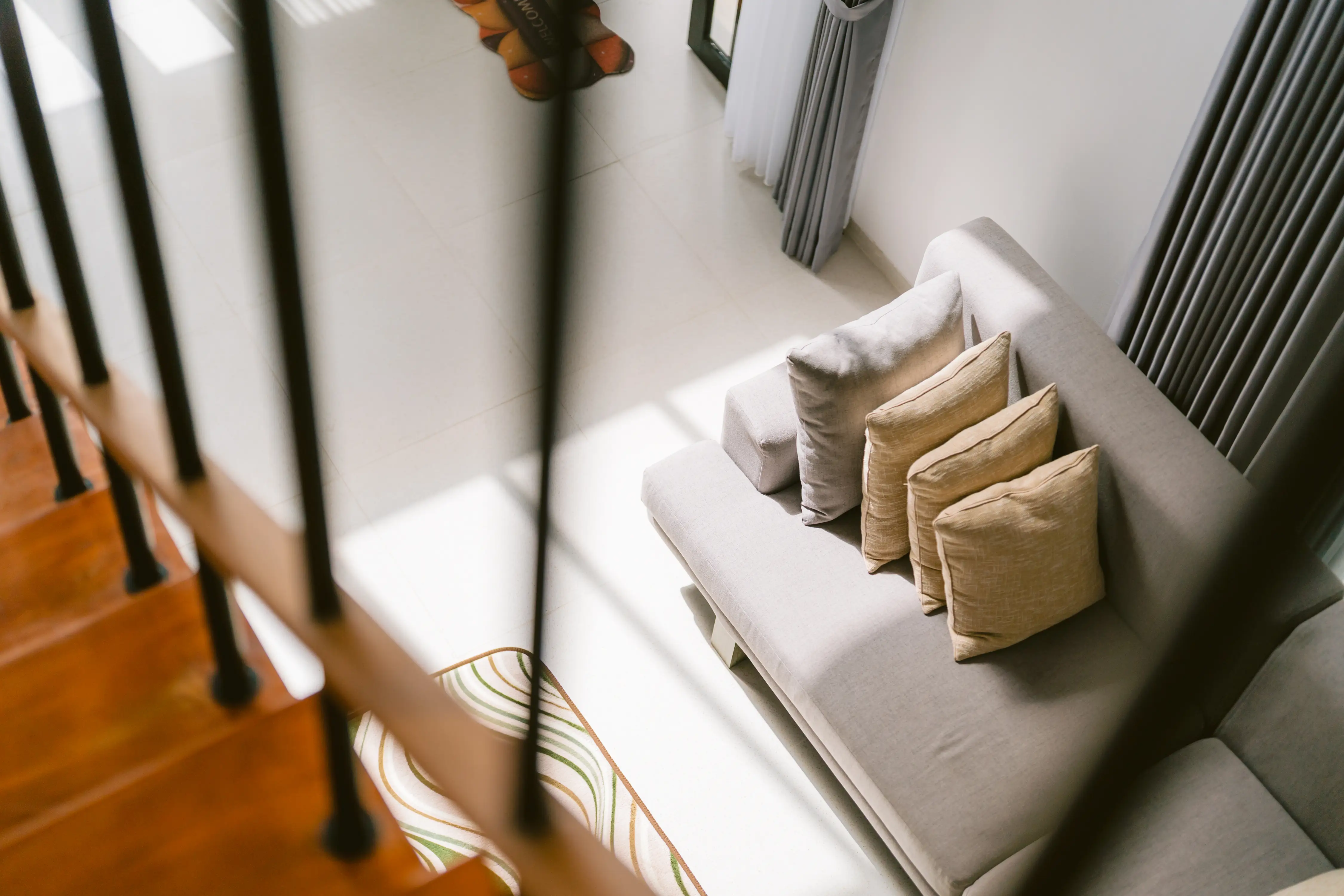Wood staircase descending alongside living area